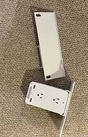 Outlet extender and detachable shelf laid out on carpet
