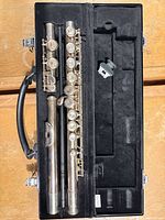 Flute disassembled in case with accessories visible