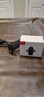 Boxed T6 wireless charger beside adjustable phone mount