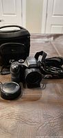 Overall view of camera with lens cap, strap, cables and Lowepro case