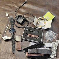 Group shot of all watches, bands, chargers and tool laid out