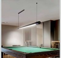 Installed view of matte black linear LED pendant above pool table
