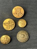 Front view of five assorted military buttons