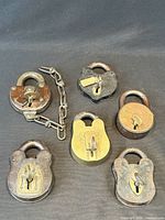 Front view of all six padlocks showing designs, one with chain, keys visible in four