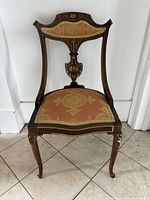 Front view of mahogany armchair showing upholstery and inlay