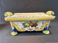 front view showing fruit motif, scroll handles, lion feet