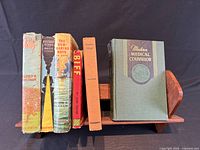Books on wooden rack showing titles and condition