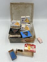 Open box showing assorted needle packages and styli