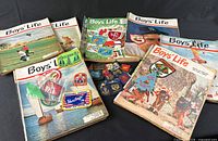 Assortment of Boys’ Life magazines with patches and pins on top