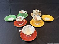 All five teacups with their saucers and two side plates displayed