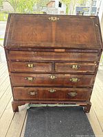 Full exterior view of slope-front walnut secretaire desk with drawers