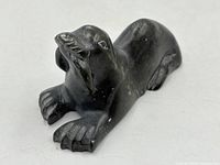 angled view of signed stone walrus sculpture showing head and flippers