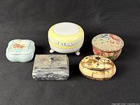 Five lidded boxes grouped for scale and comparison