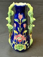 Front view showing cobalt glaze, floral relief and both handles