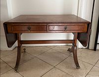 Front view showing drawers, drop leaves and castors