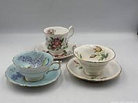 Three teacup and saucer sets displayed