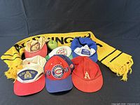 Front view showing six hats and yellow Boddingtons scarf