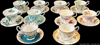 All eleven teacups with saucers displayed on black background
