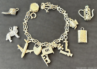 Bracelet with attached charms and four loose charms arranged around
