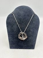 Necklace displayed with four rings threaded on chain