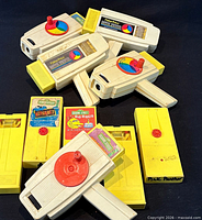 Group of five movie viewers and several cartridges spread on black background