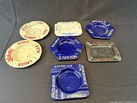 Seven ashtrays arranged to show branding, shapes and colours
