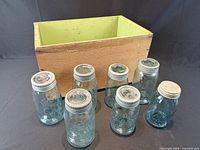 Wooden box and seven blue mason jars with lids