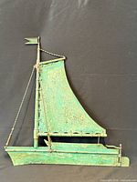 Full view of copper sailboat weathervane front side showing overall form and patina