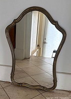 Front view of vintage French-style scalloped wall mirror showing gold and sage green frame and glass