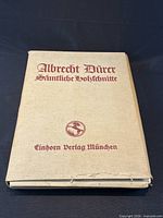 Closed tan cloth portfolio with red lettering Albrecht Dürer Sämtliche Holzschnitte Einhorn Verlag München