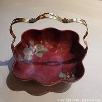 Top view of Marumi lacquerware bowl showing scalloped rim, floral painting, brass handle
