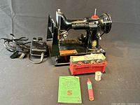 Machine with foot pedal, accessory box, manual, thread spool, lubricant tube