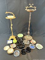 Group shot of both standing ashtray stands and fifteen tabletop ashtrays