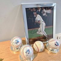 Group shot of four signed baseballs on stands and signed Paul Molitor photo in frame