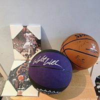 Group shot of both basketballs and two signed photo plaques