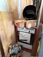 Welder cabinet with helmet on top, respirator and electrode box visible