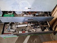 Two open drawers showing pneumatic tools, hoses, assorted hardware