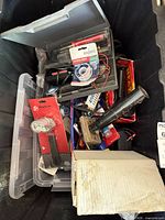 Overview of tote showing mixed tools, solder supplies, epoxy, screwdrivers, wiring