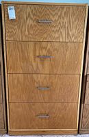 Front view of tall 4-drawer oak veneer dresser with brushed metal pulls