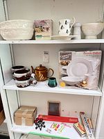 Shelf view showing Gibson box, teapot, soup bowls, green cup, mixing bowls, mug, marble mortar and pestle