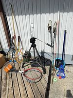 Assorted sports gear, tripod, skis, poles, rackets, lacrosse stick
