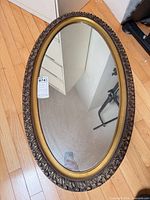 Front view of oval mirror showing frame and glass