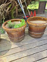 Pair of brown glazed ceramic planters on deck