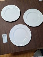All three dinner plates on table with lot tag visible
