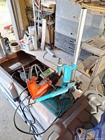 Drill press stand with Hilti drill and cords on workbench