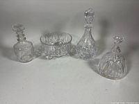 Group view of three decanters (two with stoppers) and footed bowl