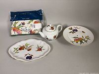 Group shot of platter, cake stand, teapot, sealed tea cozy