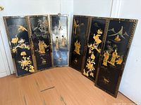 All six black lacquer wall panels leaning against wall