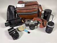Group shot showing both cameras, flash, lens, cases, bag, brush, and filter container