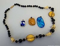 Overall lot: three pendants and bead necklace